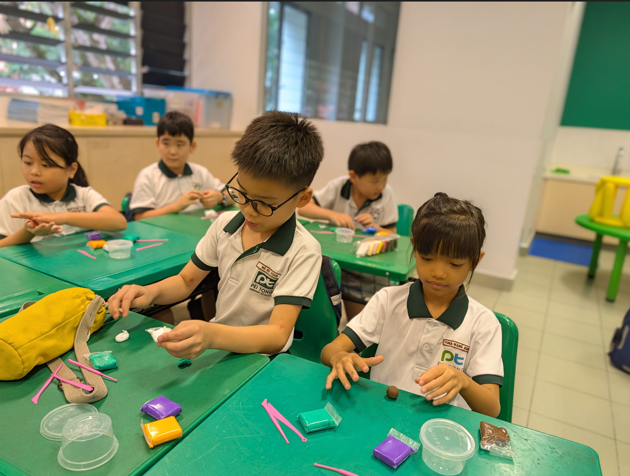 Students engaged in a classroom craft activity, carefully decorating handmade lanterns using colourful art materials and tools